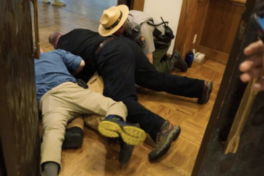 Miembros de seguridad bloquearon el paso del activista Teddy Ogborn y lo llevaron al piso en las puertas del Simposio Económico de Jackson Hole/ Climate Defiance