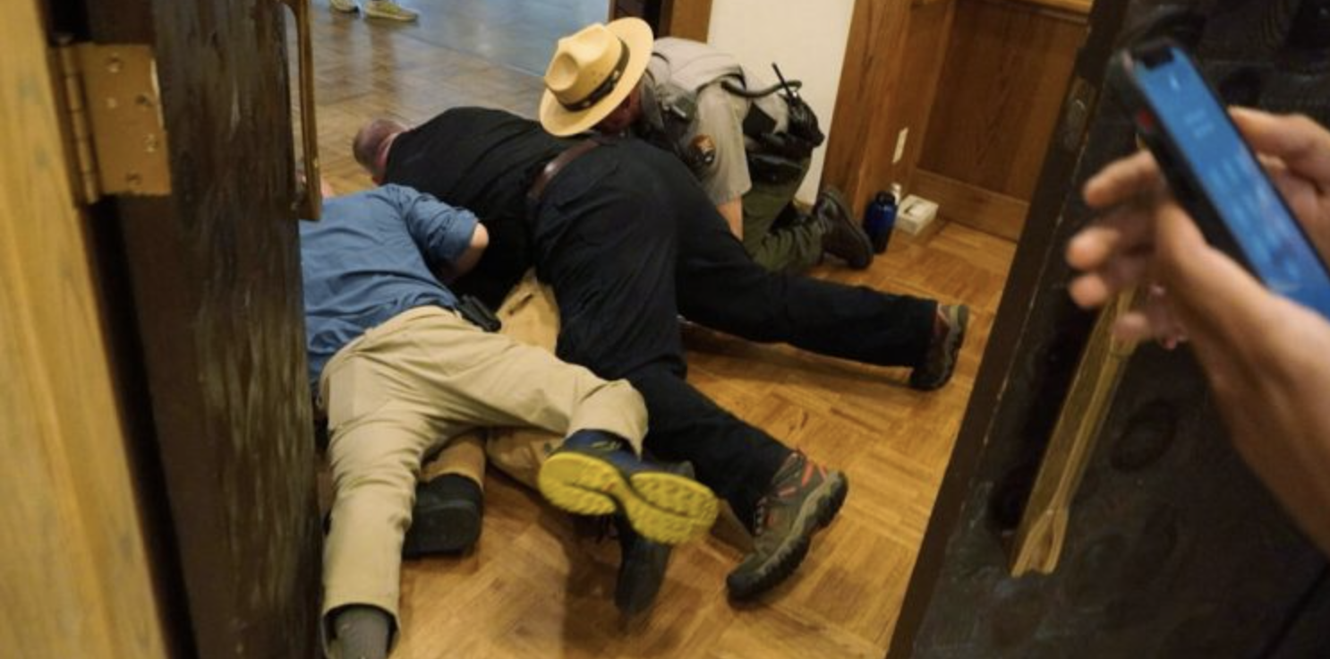 Miembros de seguridad bloquearon el paso del activista Teddy Ogborn y lo llevaron al piso en las puertas del Simposio Económico de Jackson Hole/ Climate Defiance